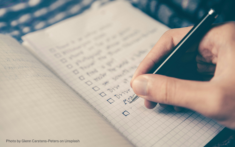 Person making a checklist in a notebook