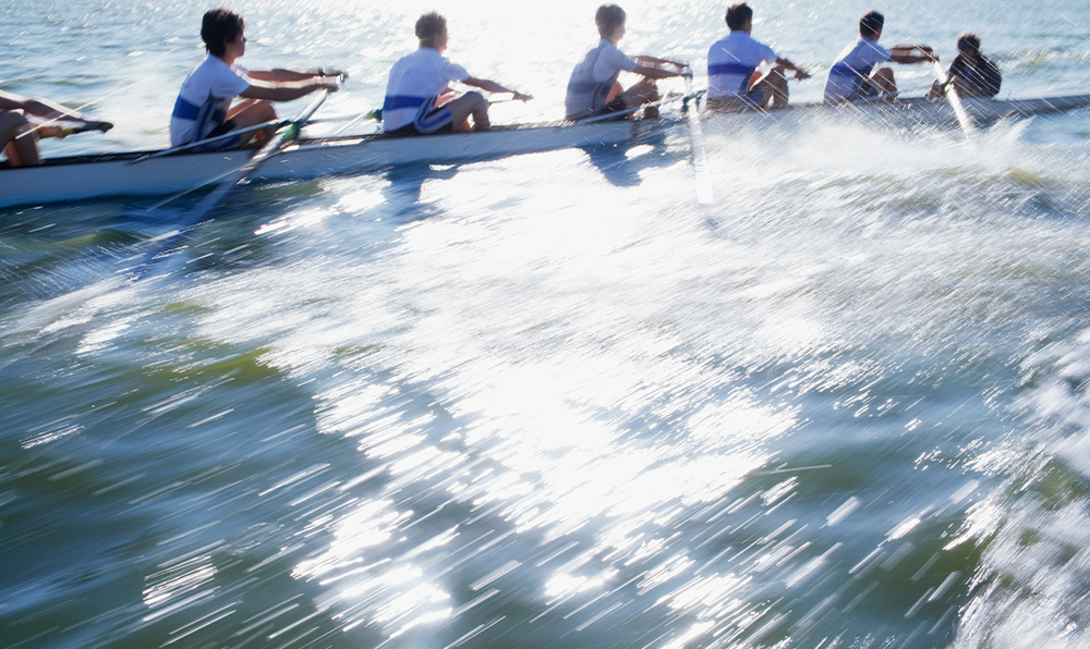 A Crew team in a river race, on sparking water with motion blur